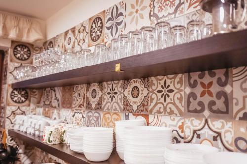 a shelf with plates and glasses on a wall at Chata Krušnohorka in Kovářská