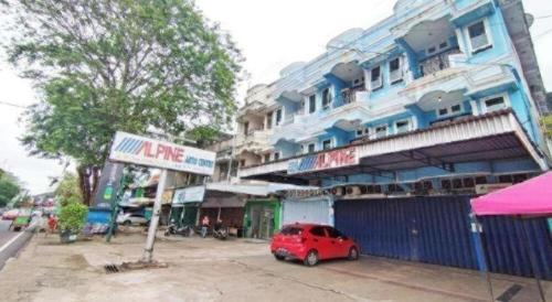 a red car parked in front of a blue building at Hotel O Benteng Kost in Jambi