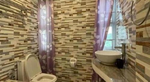 a bathroom with a toilet and a sink at Pilot Hotel in Alaminos