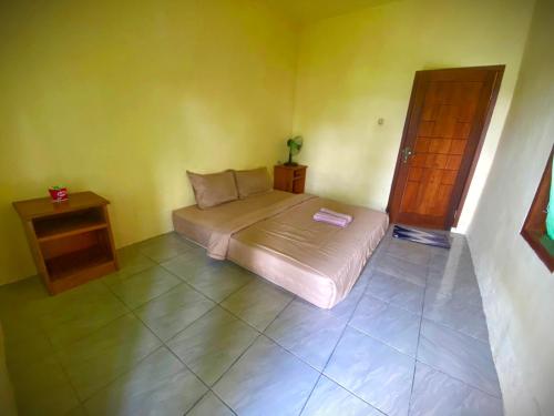 a small bedroom with a bed and a table at Pondok rinjani bungalow tetebatu in Tetebatu