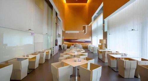 a dining room with white tables and white chairs at Jinjiang Inn Select Shanghai Fengxian Baolong Square North Yunhe Road in Shanghai