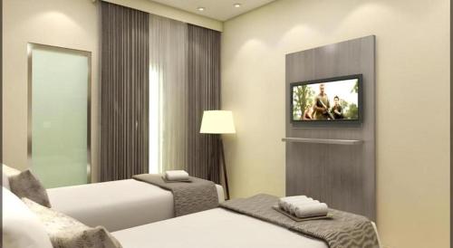 a hotel room with two beds and a television at Smart Budget Hotel in Semarang