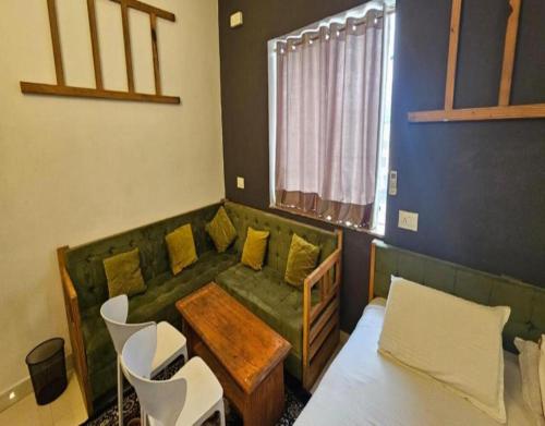 a living room with a couch and a table and chairs at Hotel 1947 & Labella Rooftop Cafe in Pushkar
