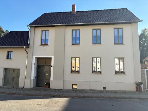 a large white house with black roof at Quartier Alte Werkstatt in Thale