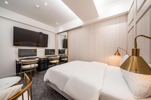a hotel room with a bed and a table and chairs at HotelInsta Main Branch in Pŏlt'ŏ