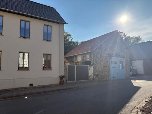 a white building with a blue door next to a house at Quartier Alte Werkstatt in Thale