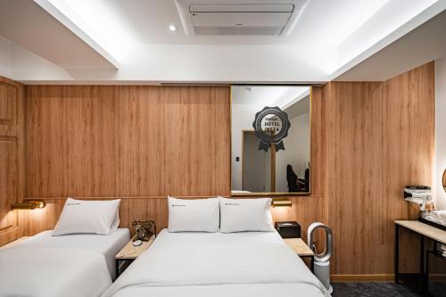 two beds in a room with wooden walls at HotelInsta Main Branch in Pŏlt'ŏ