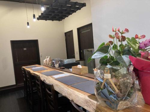 a long table with a vase of flowers on it at fujisakaya藤坂屋 in Tamba-sasayama