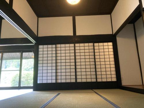 a room with tiled walls and windows in a building at fujisakaya藤坂屋 in Tamba-sasayama