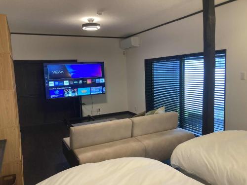 a living room with a couch and a flat screen tv at fujisakaya藤坂屋 in Tamba-sasayama