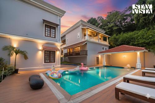 uma piscina no quintal de uma casa em StayVista at Casa Verano with Pool, BBQ em Siolim