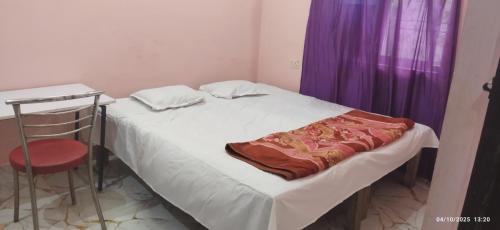 a small bedroom with a bed and a chair at Moon house in Bodh Gaya