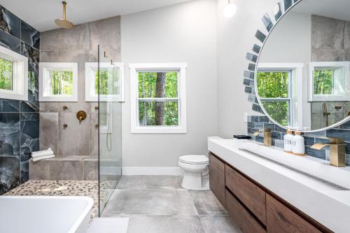 ein Badezimmer mit Waschbecken, Toilette und Spiegel in der Unterkunft H2O Oasis Tree House in Dogwood Acres