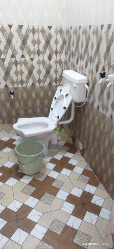 a bathroom with a toilet in a tiled floor at Moon house in Bodh Gaya