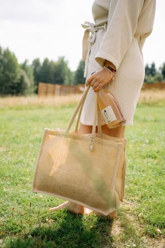 a woman holding a tan bag in a field at Patri's glamp in Mariánské Lázně