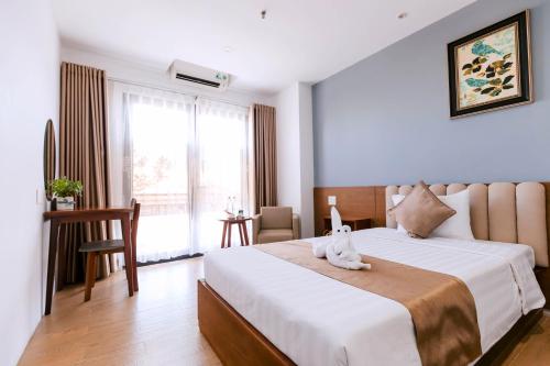 a bedroom with a large bed and a window at Gardenia Hue Hotel in Hue