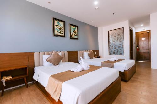 a hotel room with two beds with towels on them at Gardenia Hue Hotel in Hue