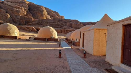 ワディ・ラムにあるRUM iSLAND bubble LUXURU CAMPの山のある砂漠の建物群