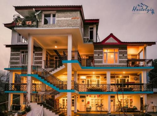 a large house with stairs in front of it at La Hostelgia in Manāli