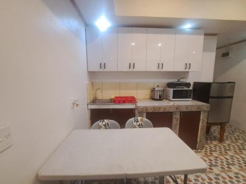 a kitchen with a white table and a counter top at Big Family Space - 3 AC Bedrooms in Apia