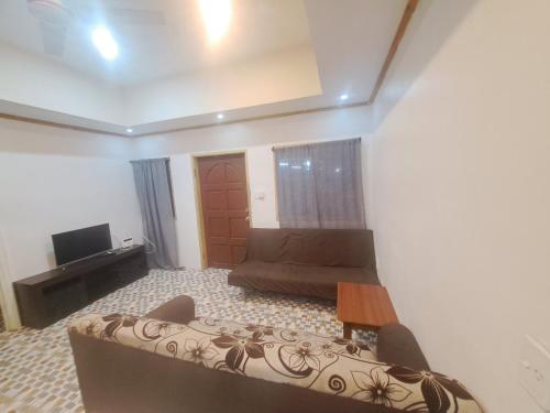 a living room with a couch and a tv at Big Family Space - 3 AC Bedrooms in Apia