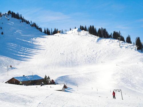 a snow covered ski slope with people skiing on it at Lush apartment in Bayrischzell with 2 saunas in Bayrischzell