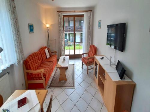 a living room with a couch and a tv at Lush apartment in Bayrischzell with 2 saunas in Bayrischzell