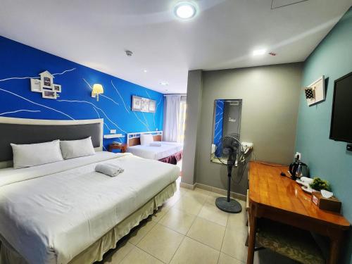 a bedroom with a large bed with a blue wall at Boutique Hote123 in Kuala Lumpur