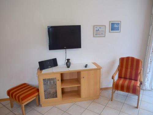 a living room with a tv and a chair at Lush apartment in Bayrischzell with 2 saunas in Bayrischzell