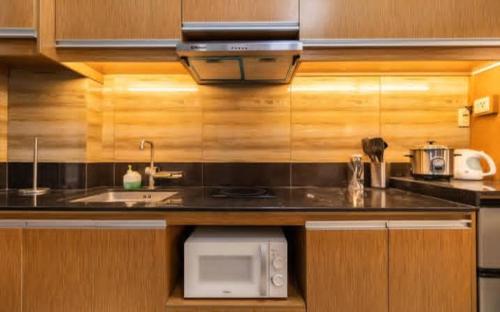a kitchen with a sink and a microwave at Pagusara's Entire Home Vacation in Cebu City