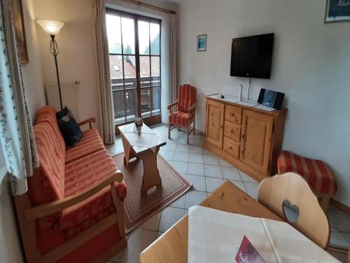 a living room with a couch and a tv at Lush apartment in Bayrischzell with 2 saunas in Bayrischzell