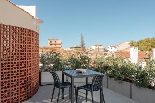 a patio with a table and chairs on a balcony at Amara Luxury Suites With Private Hot Tub in Chania Town