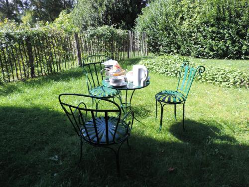 two chairs and a table with a plate of food on it at Le Numéro 1, maisonnette en Puisaye in Toucy