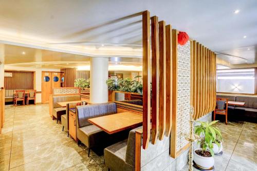 a restaurant with tables and chairs in a room at FabHotel Ratna Regency in Chinchiwad