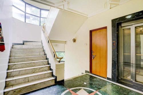 a staircase in a building with a wooden door at FabHotel Ratna Regency in Chinchiwad