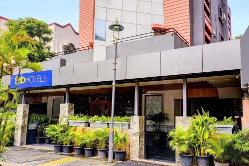 a building with potted plants in front of it at FabHotel Ratna Regency in Chinchiwad
