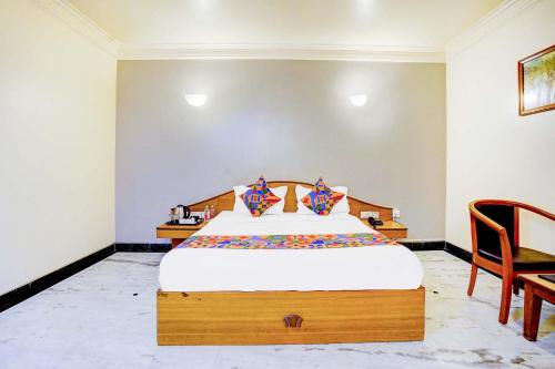 a bedroom with a large bed with a wooden headboard at FabHotel Ratna Regency in Chinchiwad