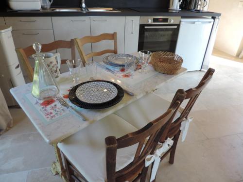 a kitchen with a table with plates and glasses on it at Le Numéro 1, maisonnette en Puisaye in Toucy
