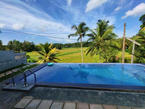 a pool with a view of a golf course at Ely Field Villa in Galle
