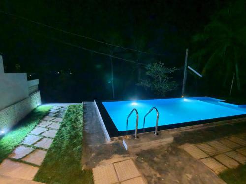 a swimming pool at night with lights on it at Ely Field Villa in Galle