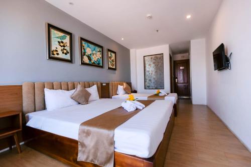 a hotel room with two beds and a television at Gardenia Hue Hotel in Hue