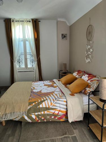 a bedroom with a bed with orange pillows and a window at Gite Centre Montbazon in Montbazon