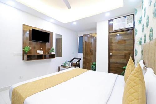 a bedroom with a bed and a tv on a wall at Hotel Vijaydeep Place Near Delhi Airport in New Delhi
