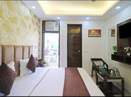 a bedroom with a large bed and a television at Hotel Vijaydeep Place Near Delhi Airport in New Delhi