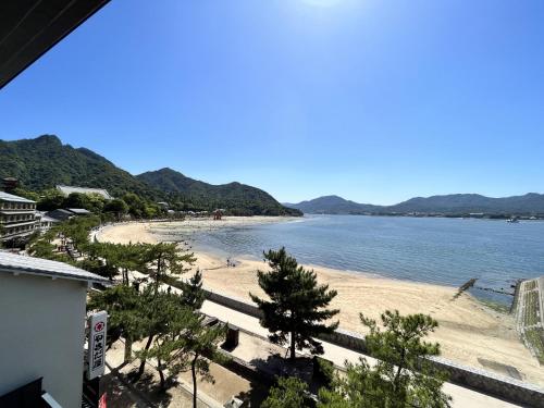 a view of a beach with trees and water at ITSUKUSHIMA IROHA in Miyajima