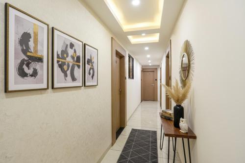 a hallway with paintings on the walls and a table at Hotel 7 Star I in Surat