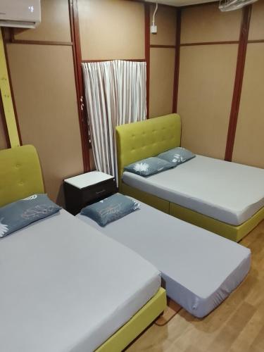 a room with two beds and a window at Benteng Taman Negara in Jerantut