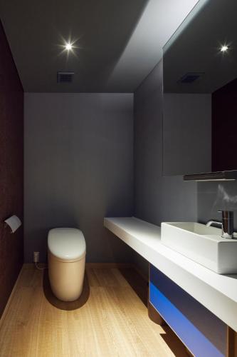 a bathroom with a white toilet and a sink at ITSUKUSHIMA IROHA in Miyajima
