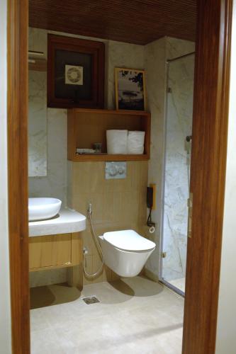 a bathroom with a toilet and a sink and a shower at Red River Retreat in Hatikhuli