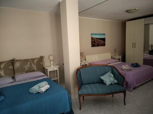 Casa Maddalena family في ماتيرا: غرفة نوم بسريرين وكرسي ازرق